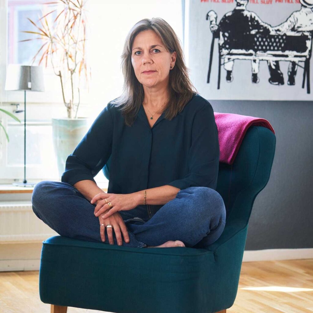 Författaren Malin Clausson sitter uppkrupen i en fåtölj
