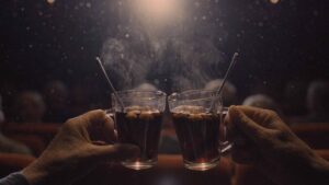 Julbio – två äldre händer som skålar i glögg i en biosalong