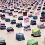 Prydliga högar med vikta kläder i rader