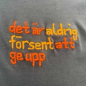 Broderi med texten "Det är aldrig för sent att ge upp"