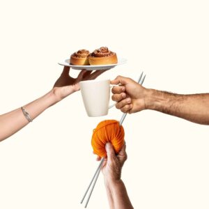 Ett fat med kanelbullar, en kaffekopp och en stickning