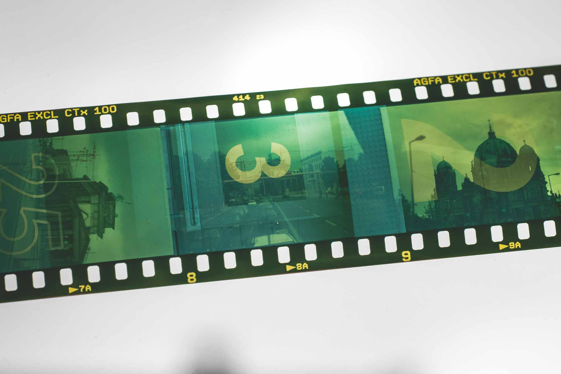 Gröngul filmremsa med stillbilder med siffror och byggnader på