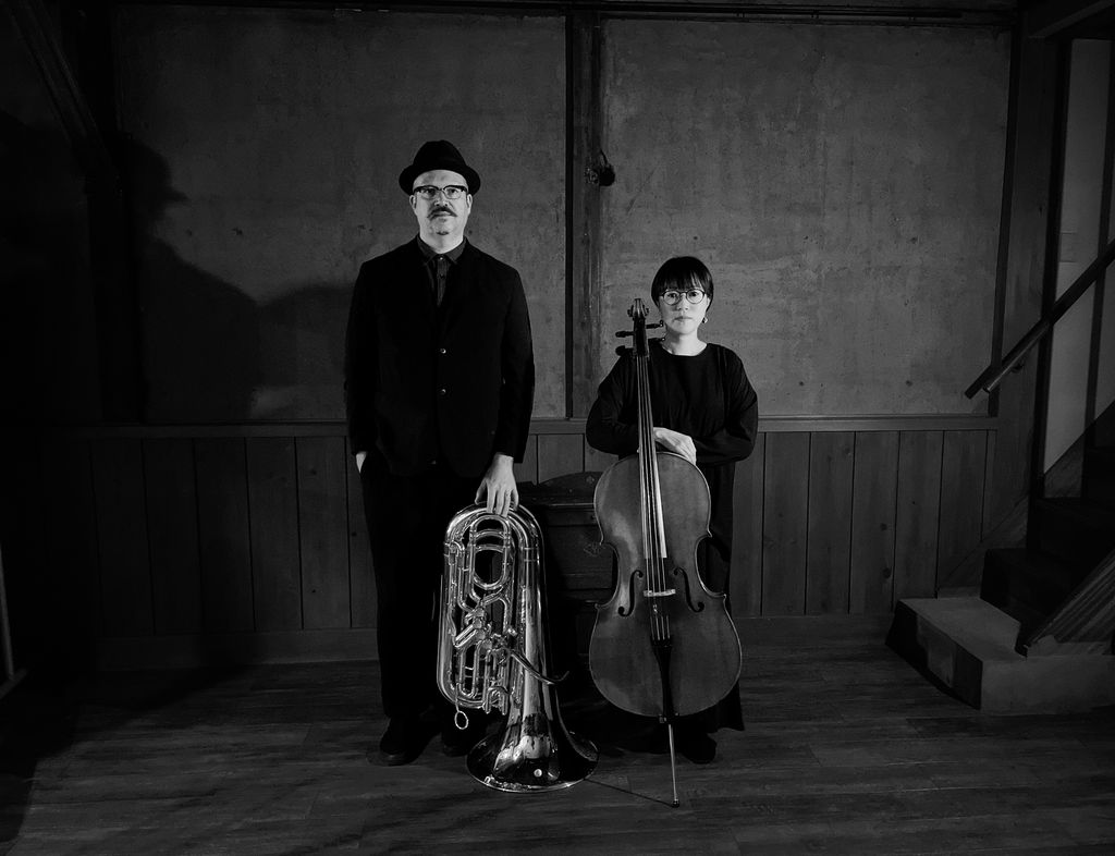 Svartvitt foto med två allvarliga musiker, den ena med tuba, den andra med cello